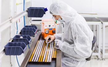 people in white isolating costumes working in laboratory